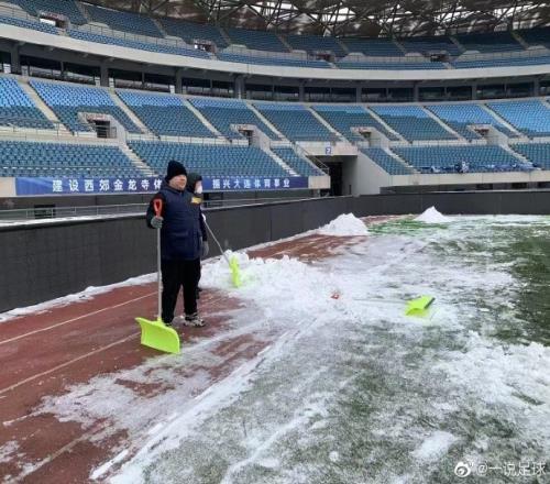 大连体育中心工作人员正努力铲雪,保障今天下午比赛如期进行
